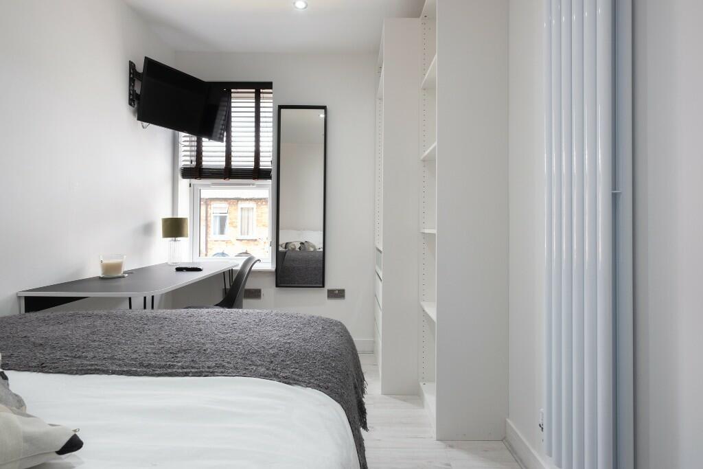 A bright and modern bedroom featuring a double ...