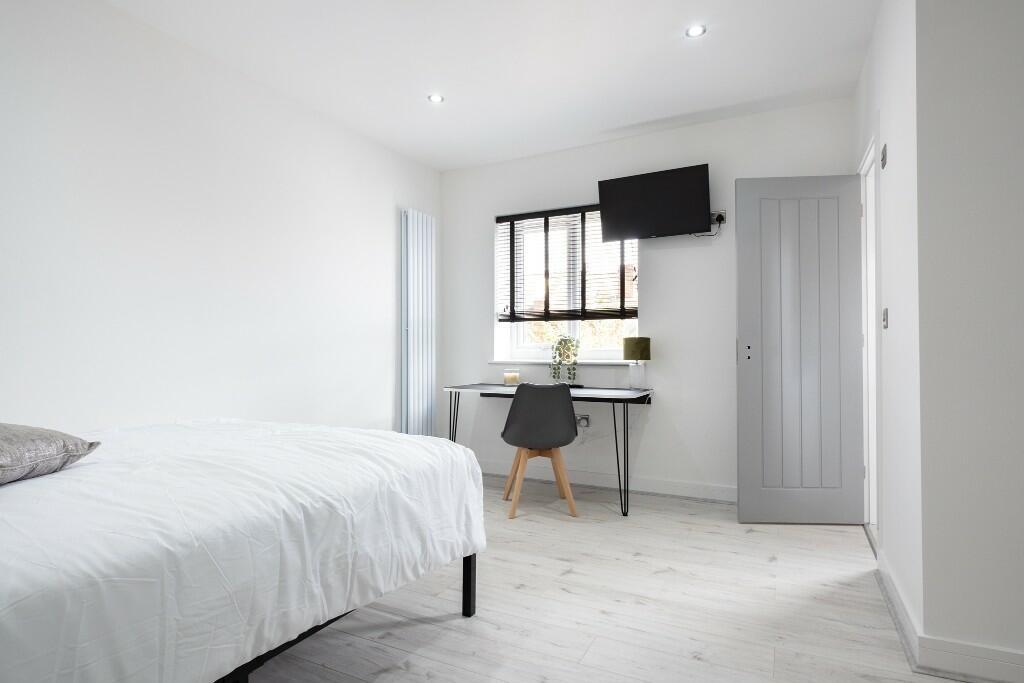 A compact bathroom featuring a clean, white aes...