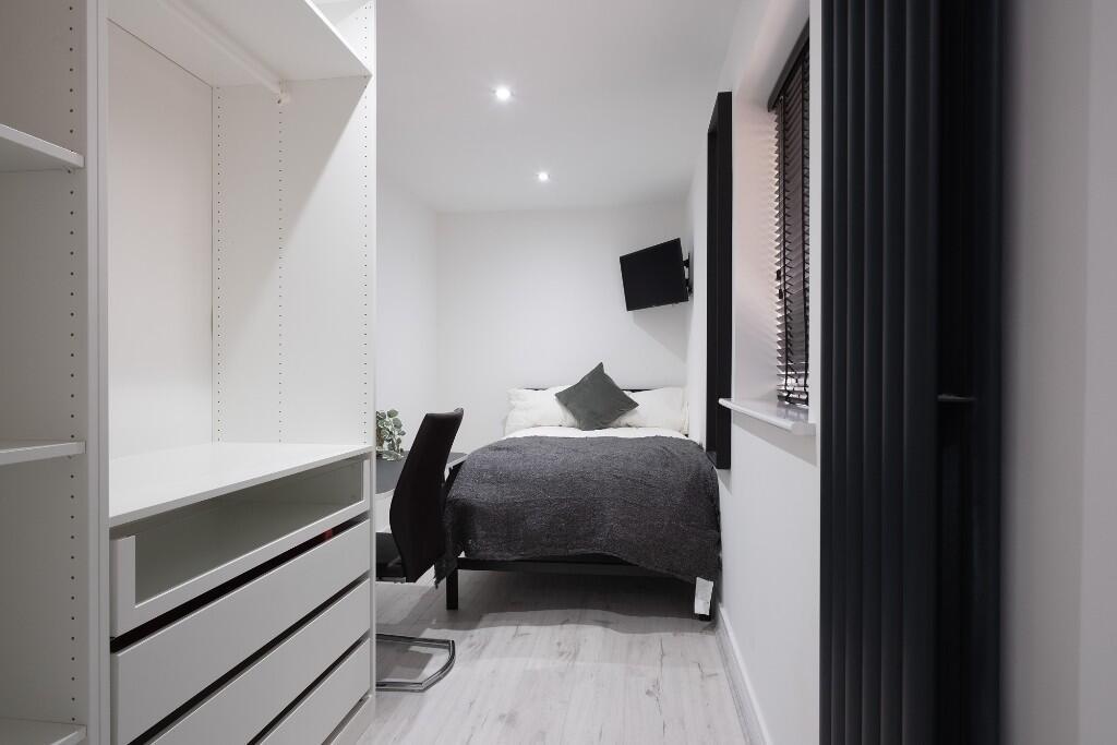 A modern, well-lit bedroom featuring a double b...