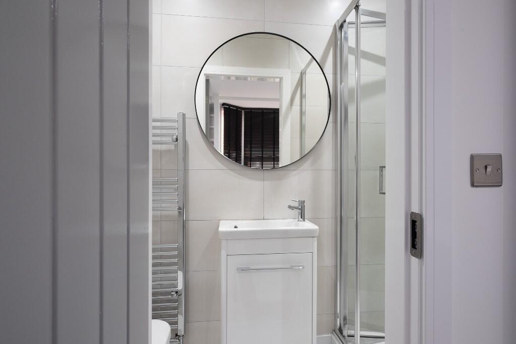 A clean and modern bathroom with a white vanity...