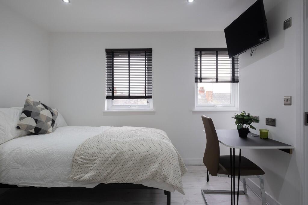 A bright and minimalist double bedroom featurin...