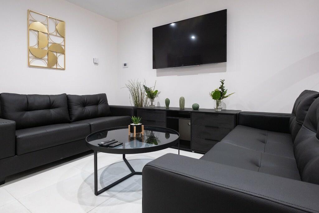 A modern, spacious living room featuring a larg...