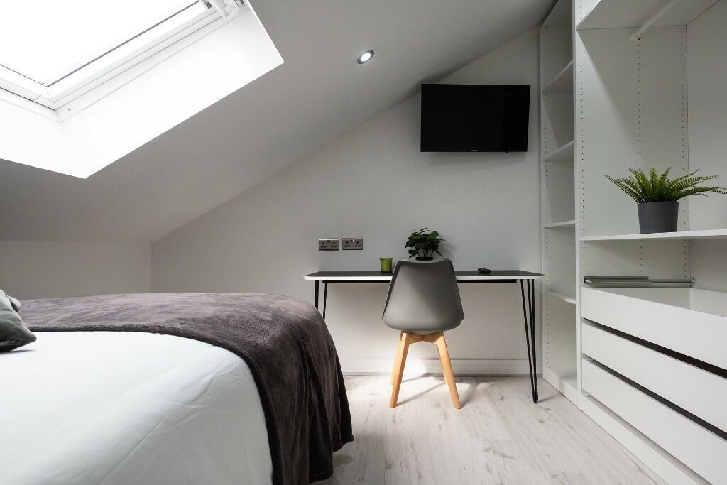 A bright and clean bedroom featuring a bed, a s...