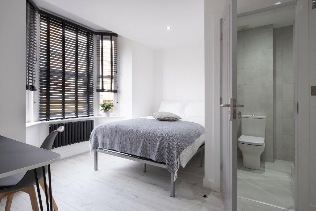 A bright and modern master bedroom featuring a ...