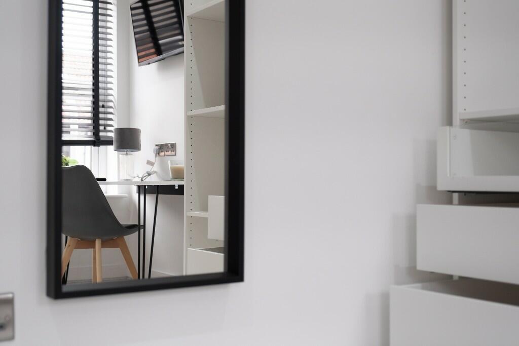 A modern and well-lit master bedroom features a...
