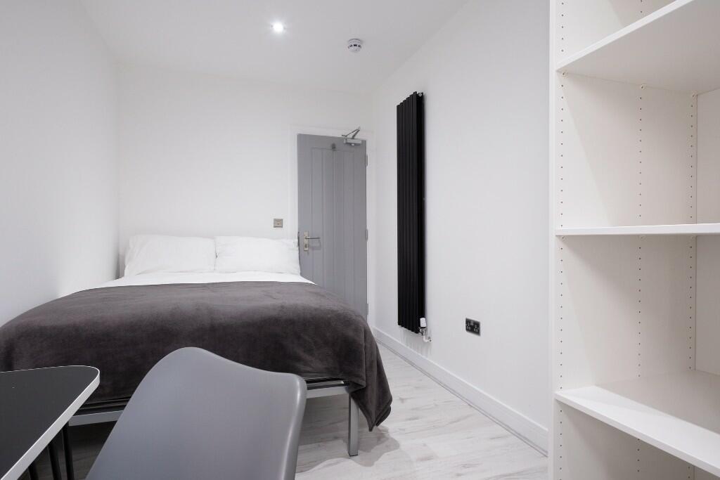 A bright, modern bedroom featuring a comfortabl...
