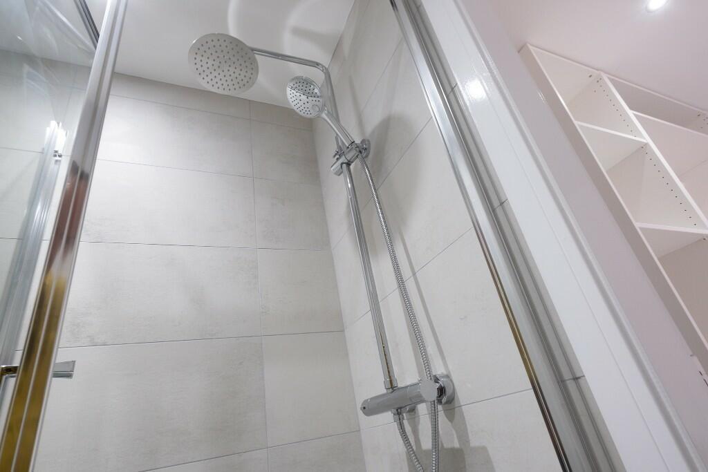 A clean and modern bathroom with a spacious sho...