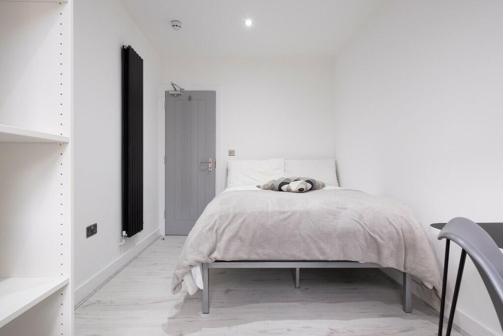 A bright and tidy single bedroom featuring a co...