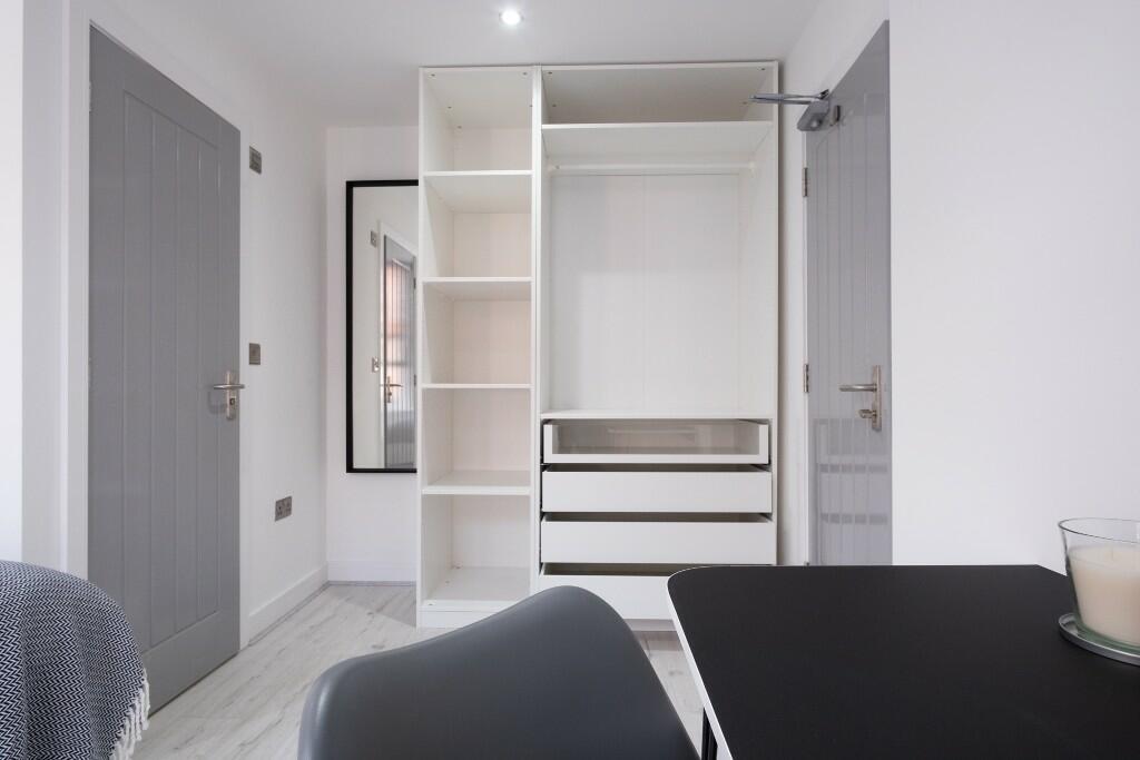 Bright, tidy bedroom with built-in open wardrob...