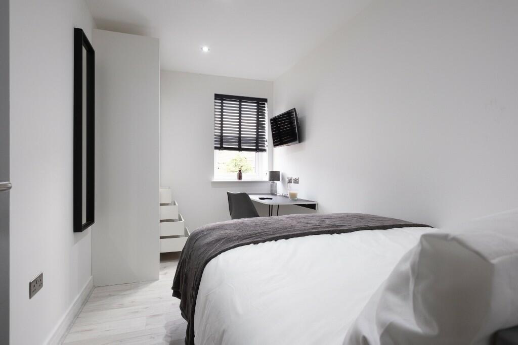 A bright and clean bedroom featuring a comforta...