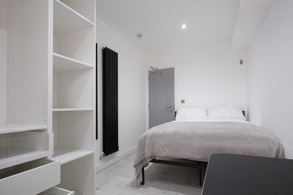 A bright and minimalist bedroom featuring a com...