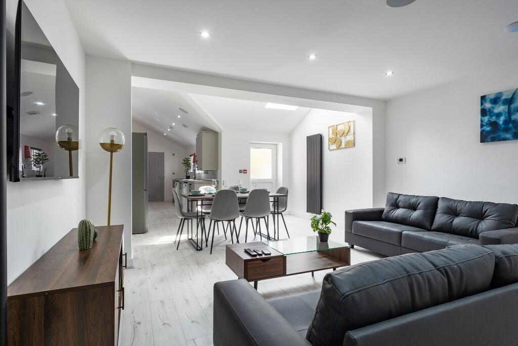 A spacious and modern living room featuring sty...