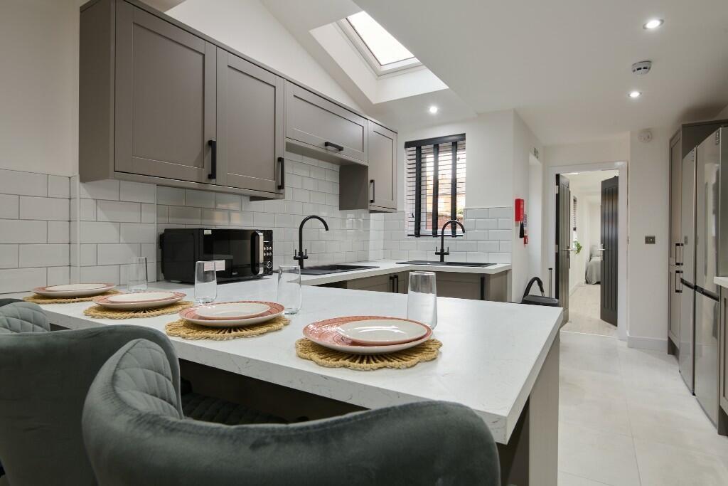A modern, well-lit kitchen featuring sleek cabi...
