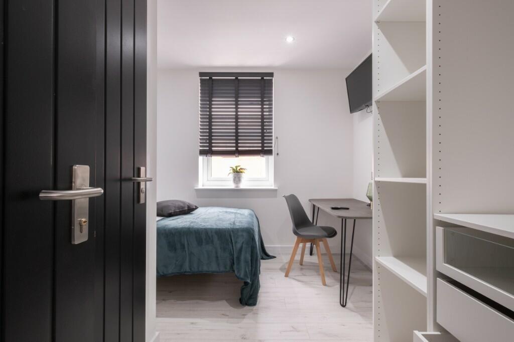 A bright and modern bedroom featuring a comfort...