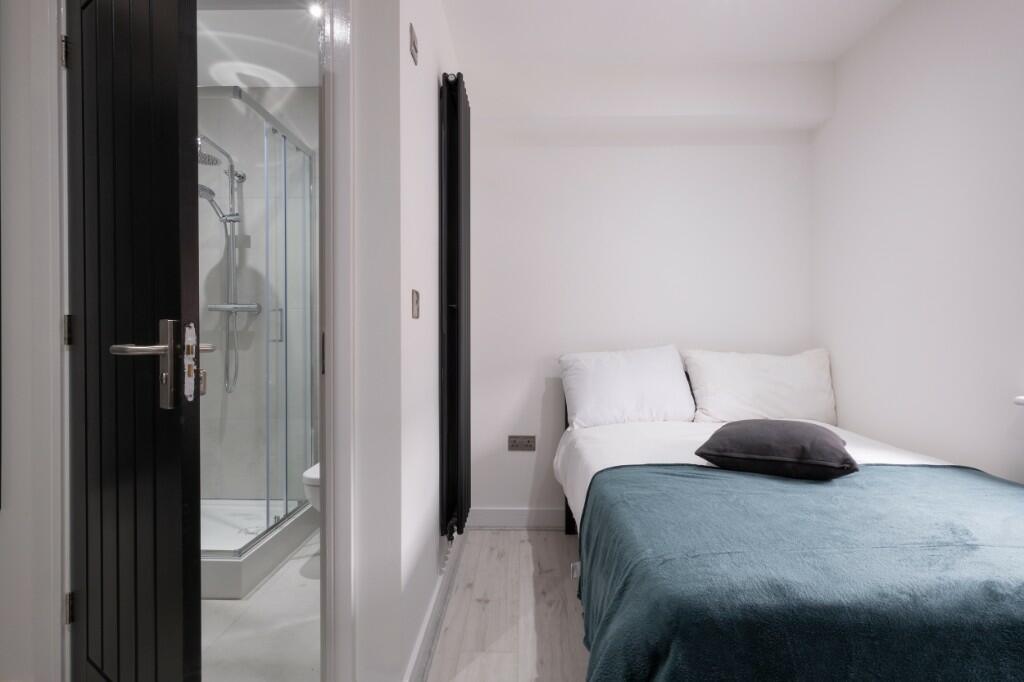 A bright and tidy bedroom featuring a double be...