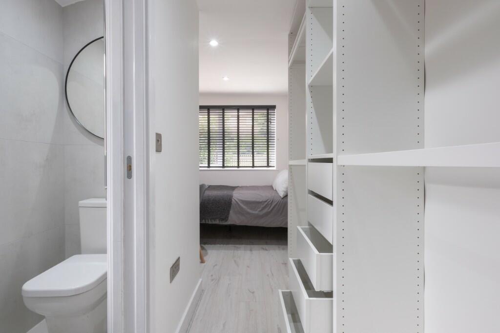 Bright, modern bedroom suite with integrated sh...