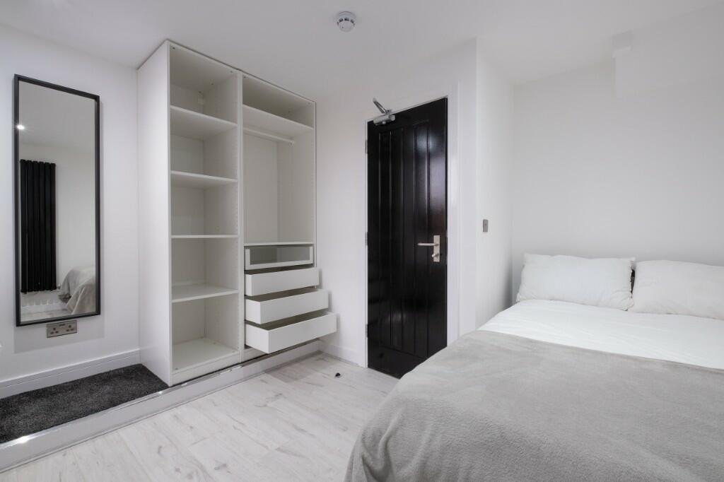 A modern and tidy bedroom featuring a comfortab...