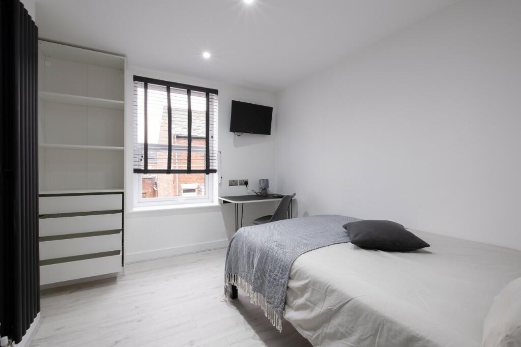A bright, tidy bedroom featuring a modern bed w...