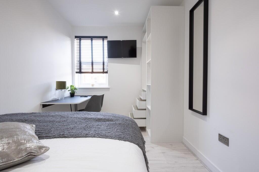 A bright, modern bedroom featuring a comfortabl...