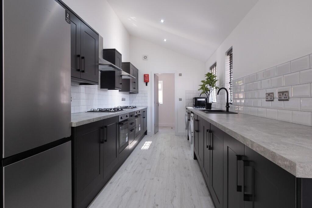 A modern, well-lit kitchen with sleek black cab...