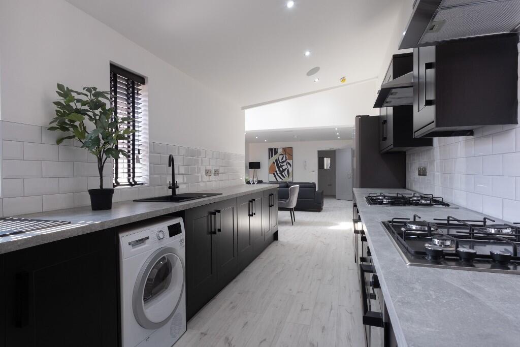 Modern and well-lit kitchen featuring black cab...