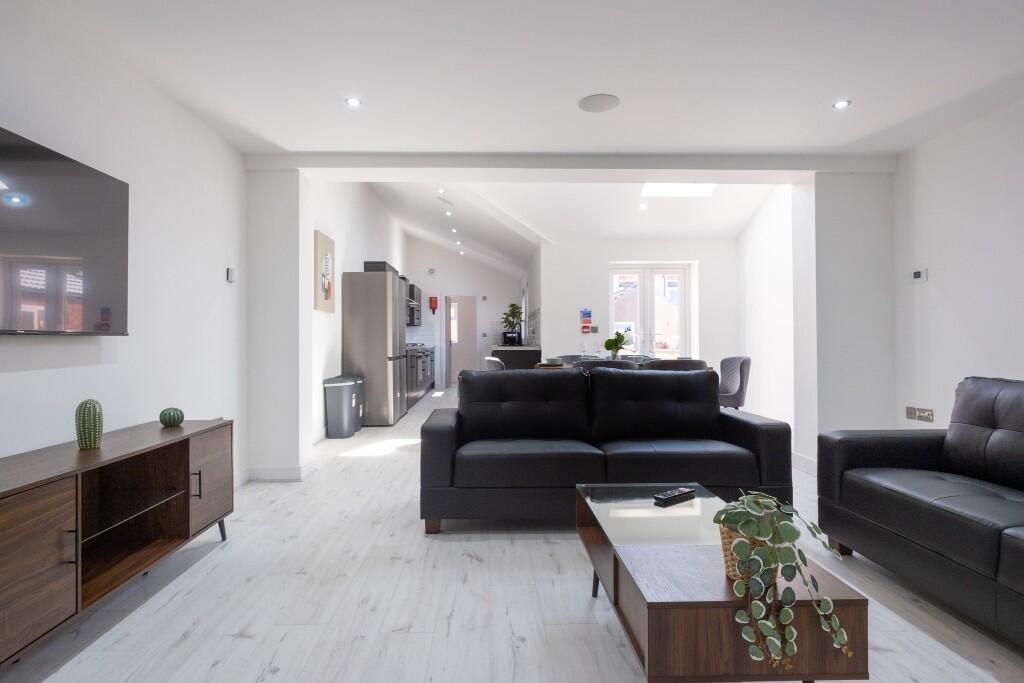 A bright, modern living room with large windows...