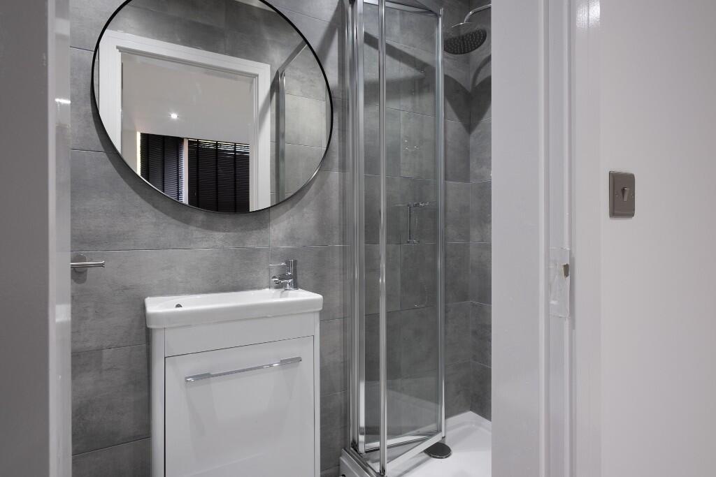 Modern bathroom featuring a shower enclosure an...