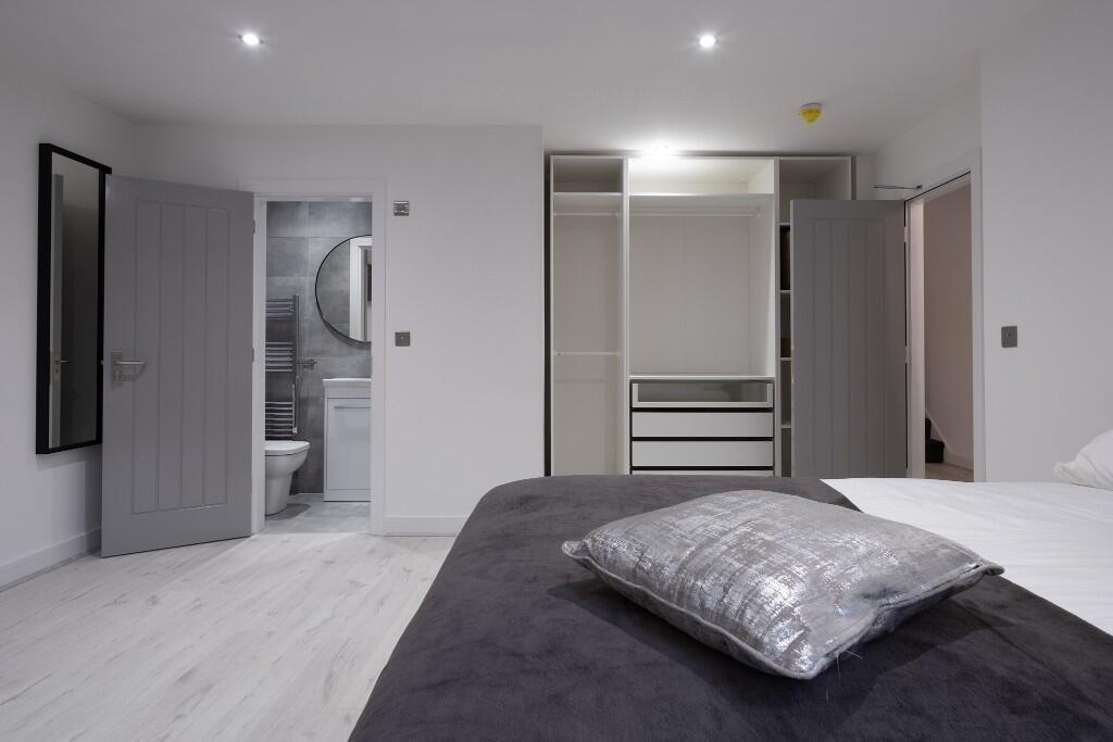 A bright and modern master bedroom featuring a ...