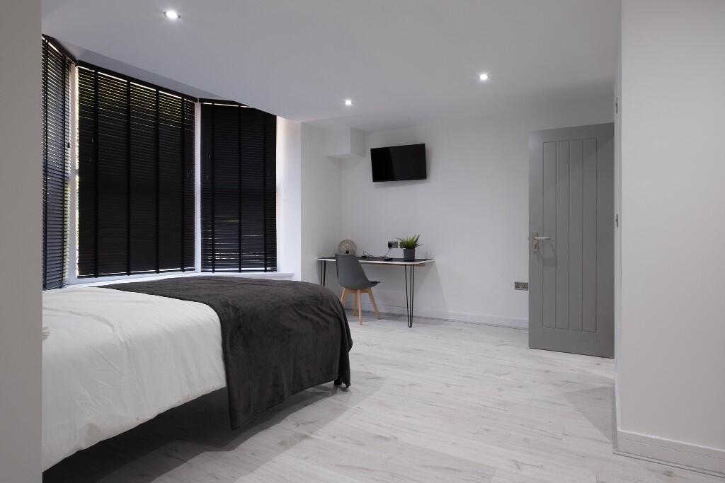 A spacious and modern master bedroom with a lar...