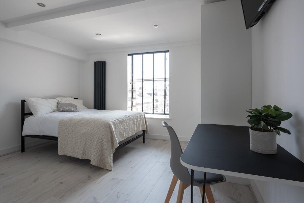 A bright and spacious master bedroom featuring ...