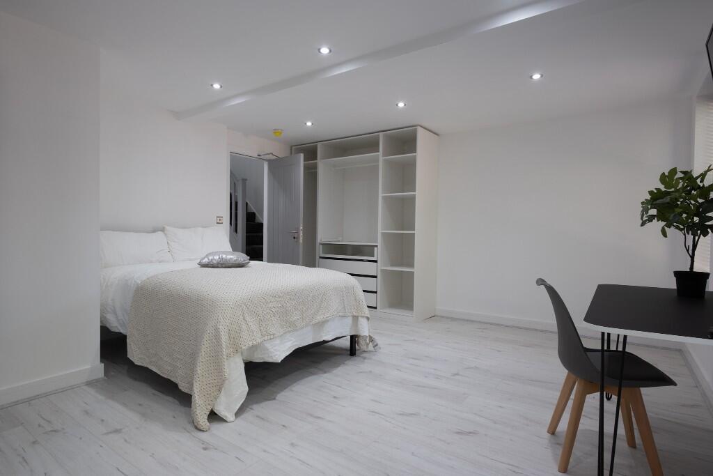 A spacious and modern master bedroom featuring ...