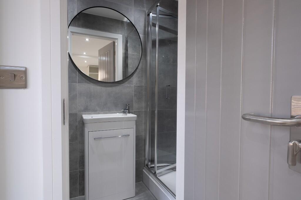 A clean and modern bathroom featuring a shower ...