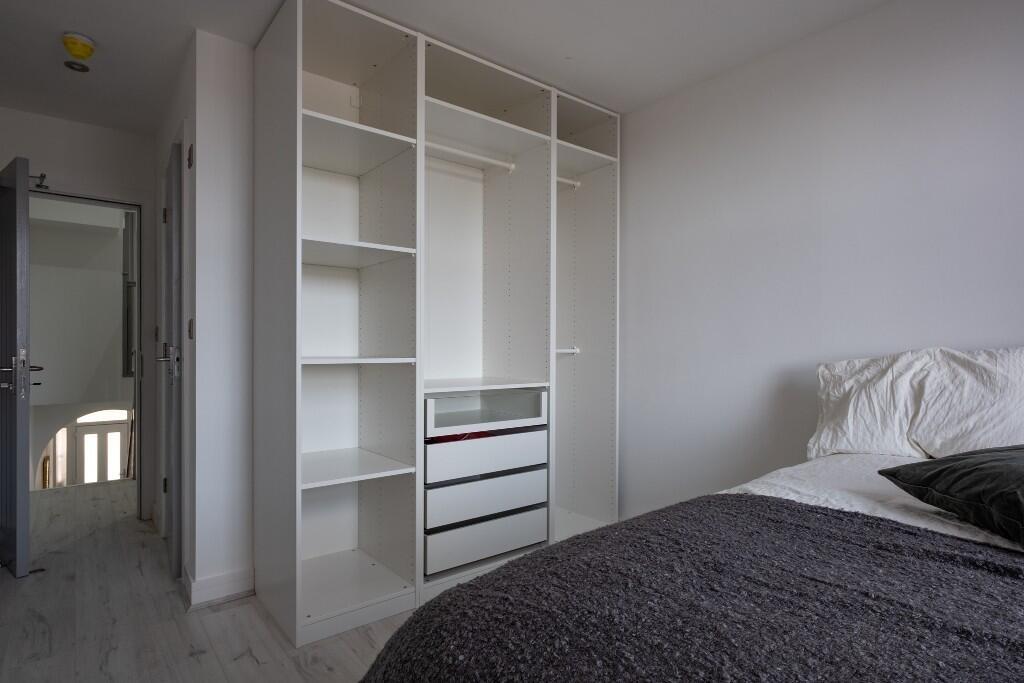 A bright and tidy bedroom featuring a large war...