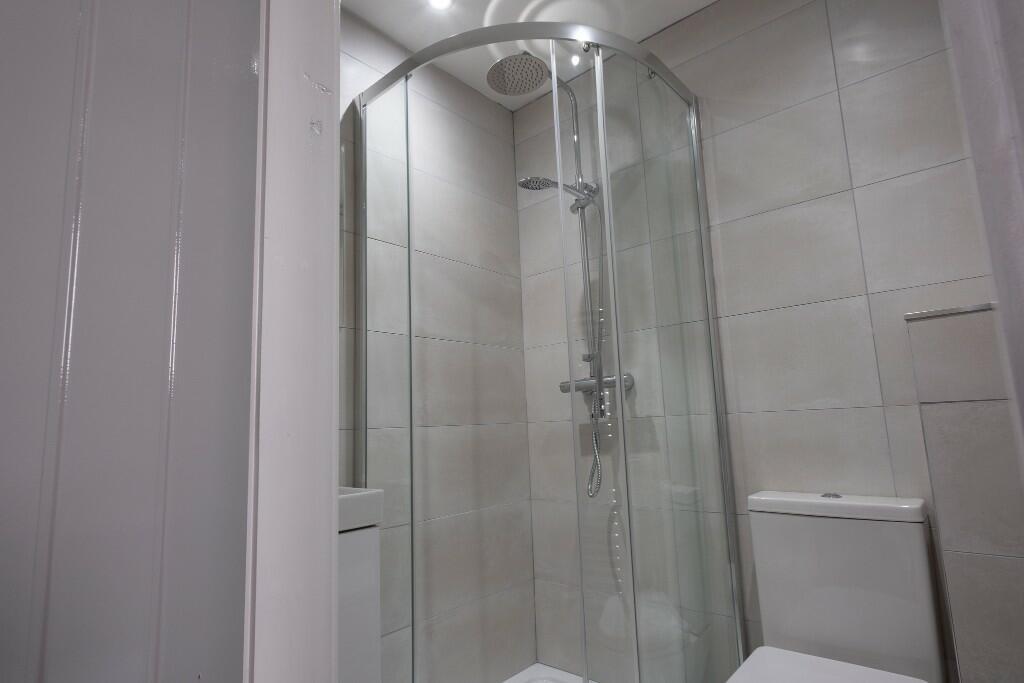 A clean, modern bathroom with a spacious shower...