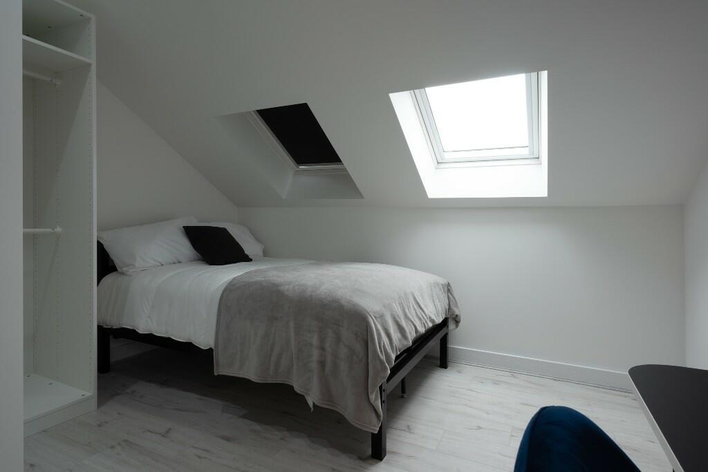 A bright and tidy bedroom with a comfortable do...
