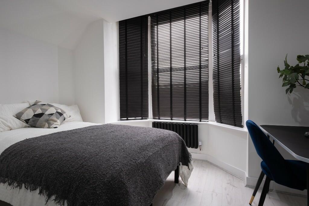 A cozy and well-maintained bedroom with a large...