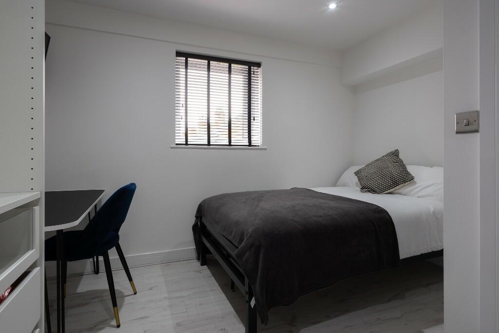 A clean and modern student bedroom featuring a ...