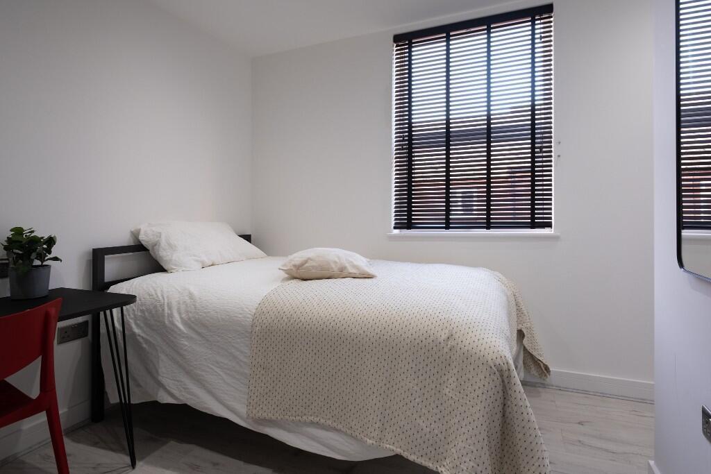 A bright and welcoming master bedroom featuring...