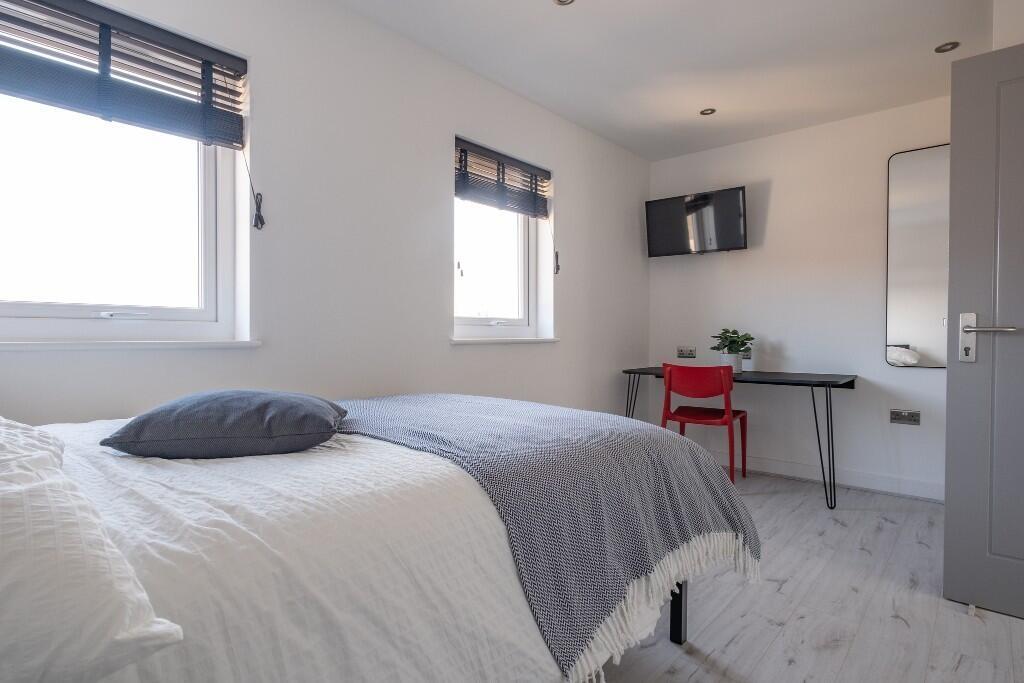 A bright and inviting bedroom featuring a comfo...