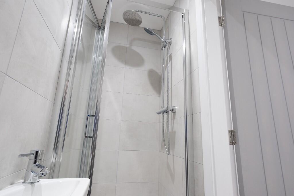 A clean and bright bathroom featuring a large s...