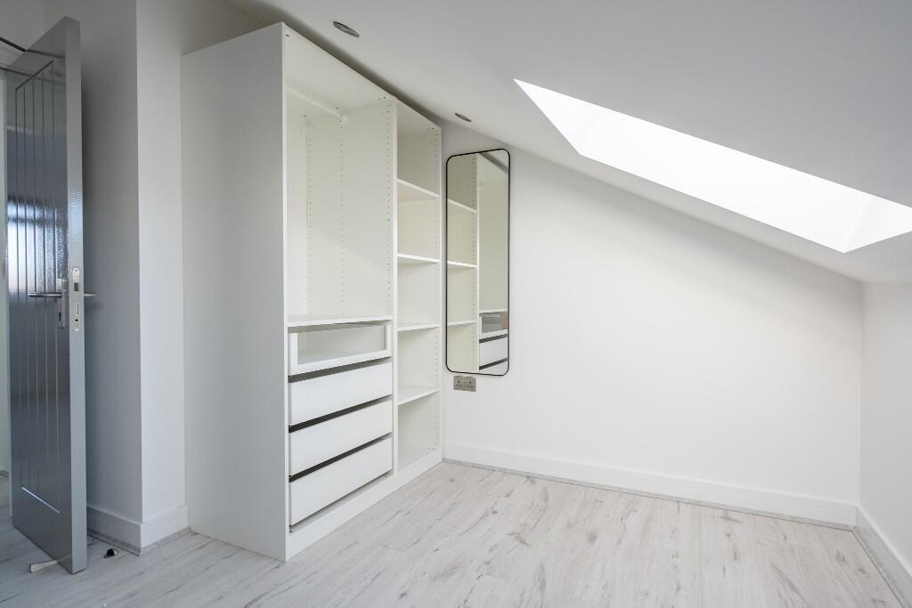 Bright, modern bedroom with built-in storage an...