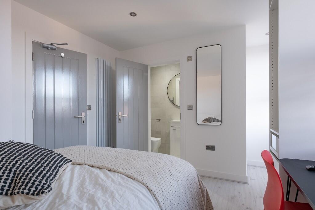 A bright and tidy bedroom featuring a comfortab...