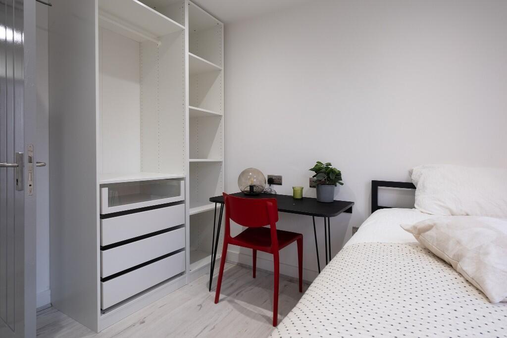 Bright and modern master bedroom featuring a la...