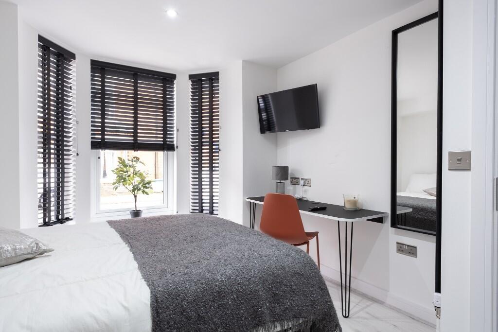 Bright and spacious master bedroom with large w...