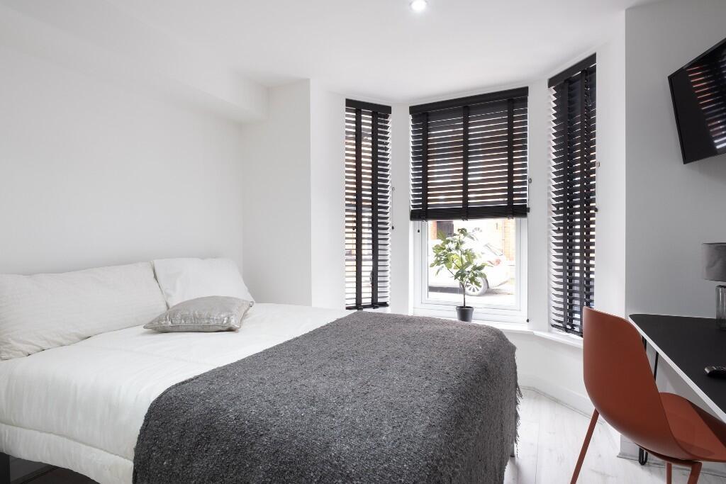 A modern, well-lit bedroom featuring a large do...