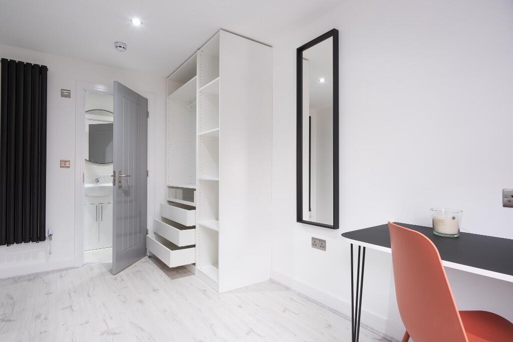 Bright, modern single bedroom with built-in she...