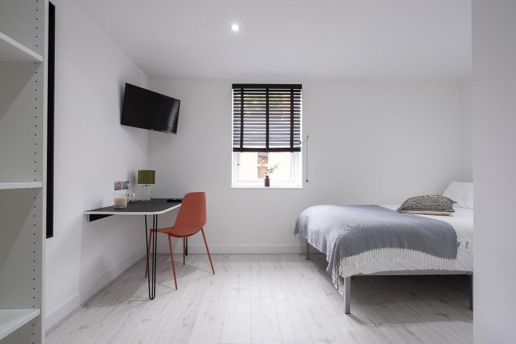 A bright, modern bedroom featuring two single b...