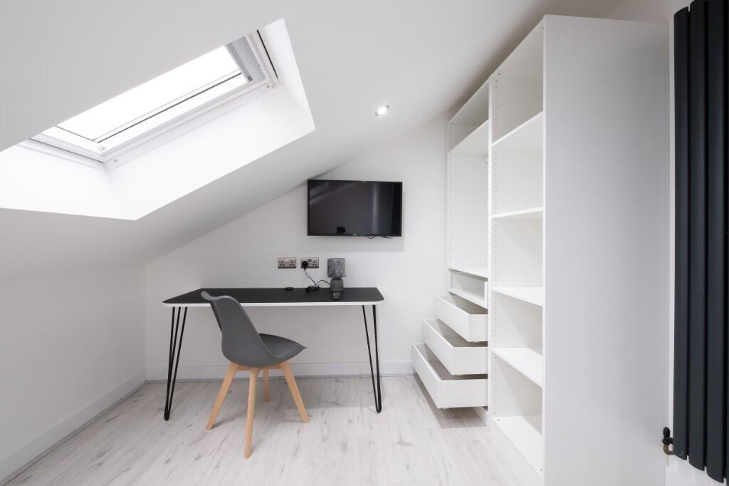 Bright, modern attic workspace with a sleek des...