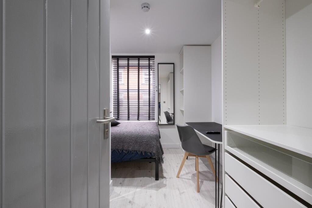 A bright and tidy bedroom featuring a comfortab...