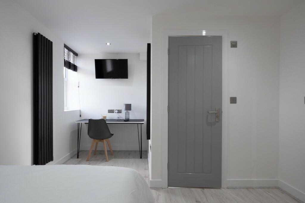A bright and tidy bedroom featuring a clean, mi...